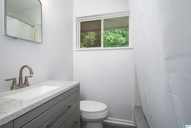 full bathroom featuring toilet, wood finished floors, and vanity