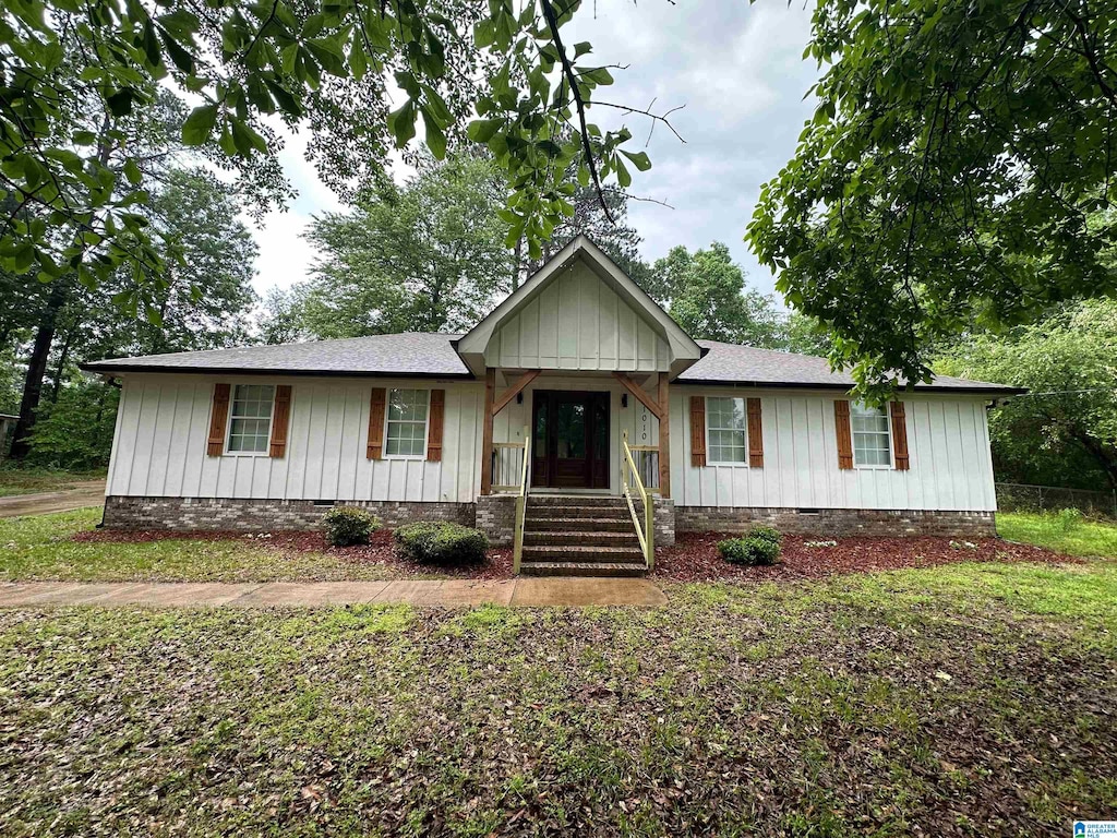 single story home featuring board and batten siding, a shingled roof, and crawl space