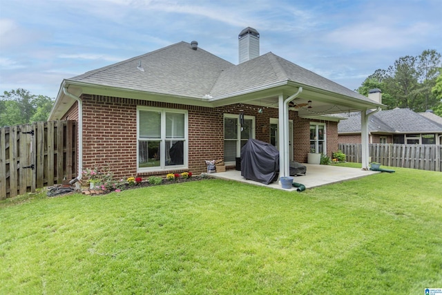 back of house featuring ceiling fan, a patio, a fenced backyard, roof with shingles, and brick siding