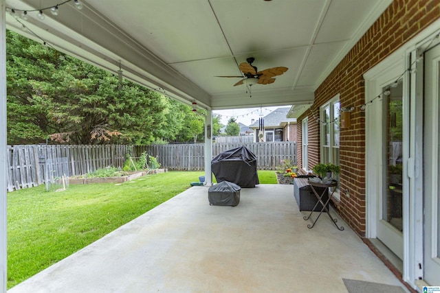 view of patio / terrace with a fenced backyard, ceiling fan, and a garden
