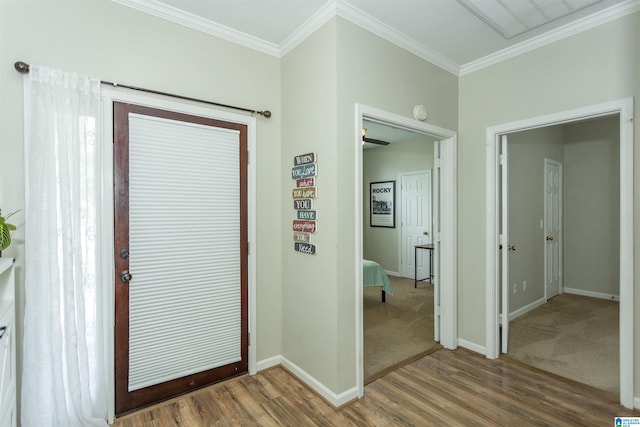 foyer with crown molding, baseboards, and wood finished floors