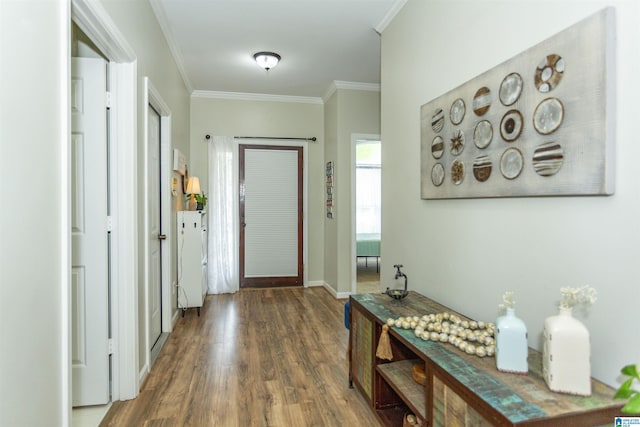 interior space featuring baseboards, ornamental molding, and wood finished floors