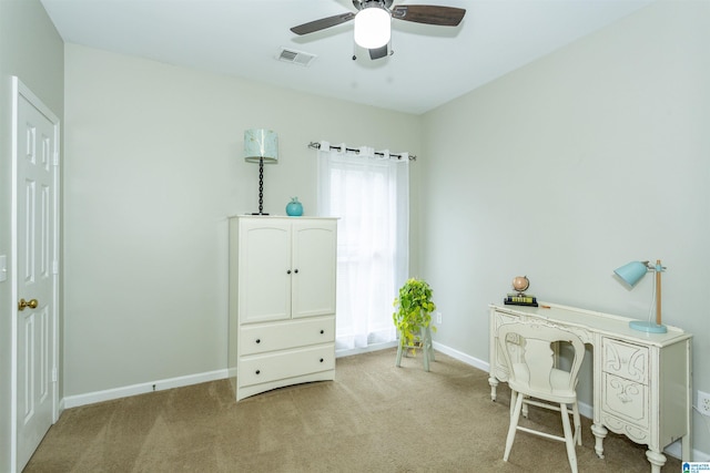 office featuring baseboards, ceiling fan, light carpet, and visible vents