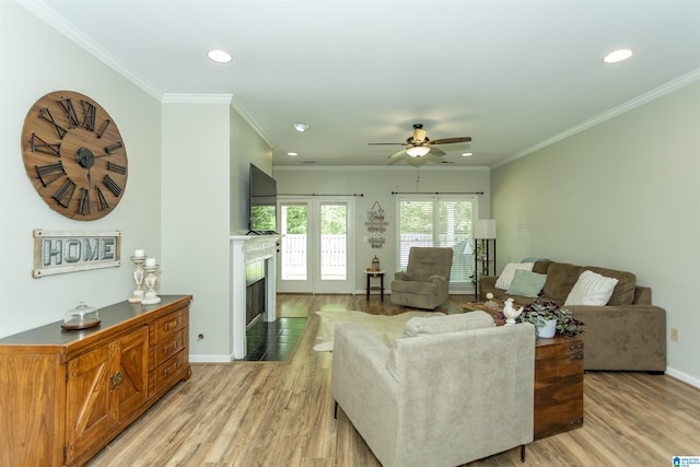 living area with recessed lighting, a ceiling fan, light wood-style flooring, and a fireplace with flush hearth
