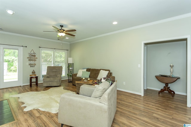 living area featuring crown molding, ceiling fan, baseboards, and wood finished floors