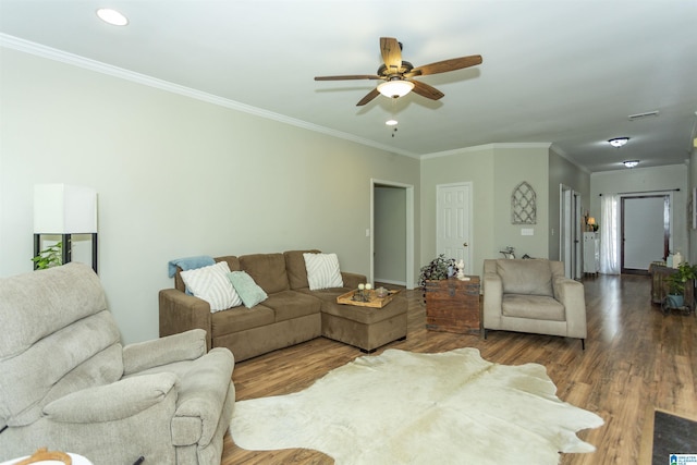 living area featuring baseboards, ornamental molding, ceiling fan, and wood finished floors
