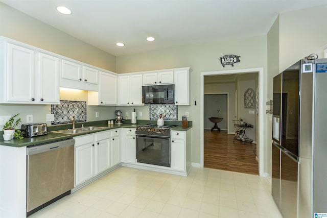 kitchen featuring a sink, white cabinetry, black appliances, and dark countertops