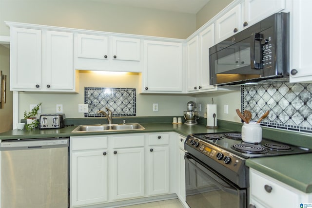 kitchen featuring dark countertops, tasteful backsplash, a sink, white cabinets, and black appliances
