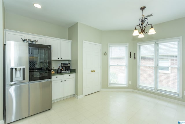 kitchen with an inviting chandelier, dark countertops, baseboards, white cabinets, and stainless steel fridge with ice dispenser