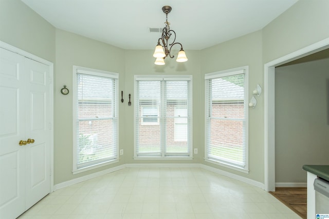 unfurnished dining area featuring an inviting chandelier, baseboards, and visible vents