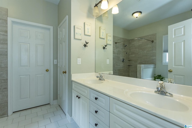 full bathroom with double vanity, a tile shower, a sink, and tile patterned flooring