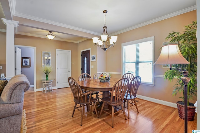 dining space featuring crown molding, baseboards, an inviting chandelier, and light wood-style flooring