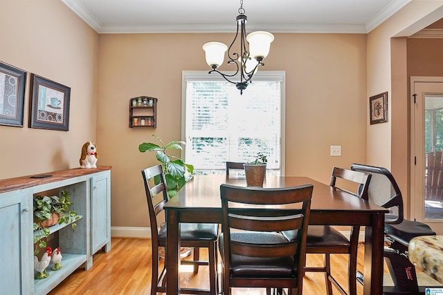 dining room featuring crown molding, baseboards, an inviting chandelier, and light wood-type flooring