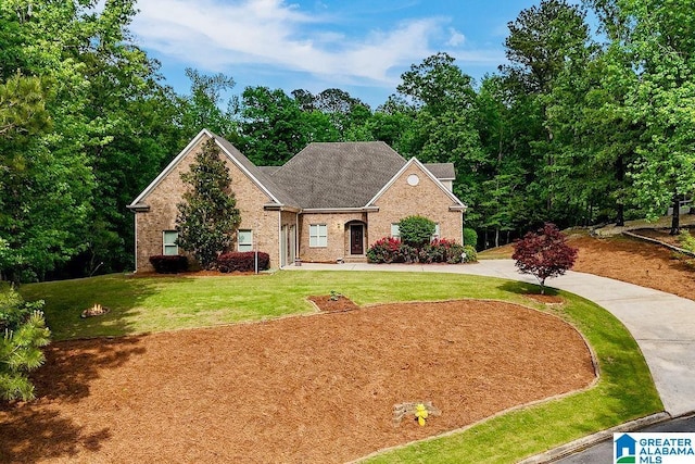 traditional-style house featuring a front yard and brick siding