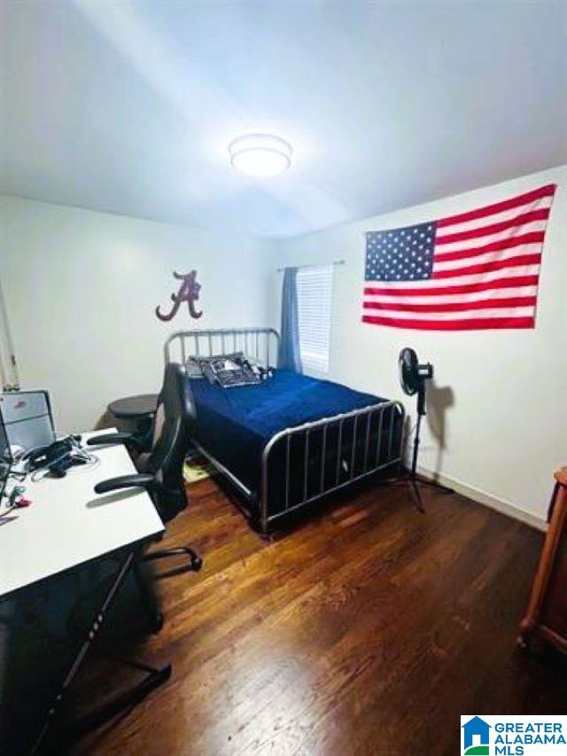 bedroom featuring wood finished floors and baseboards