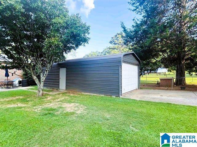 view of outbuilding featuring fence and an outbuilding