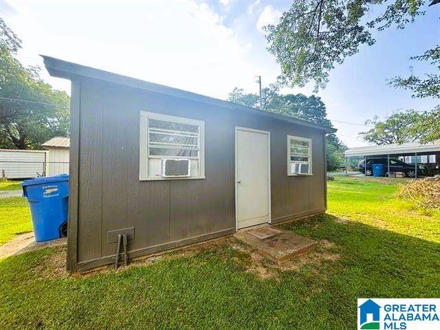 view of outdoor structure with cooling unit and an outbuilding