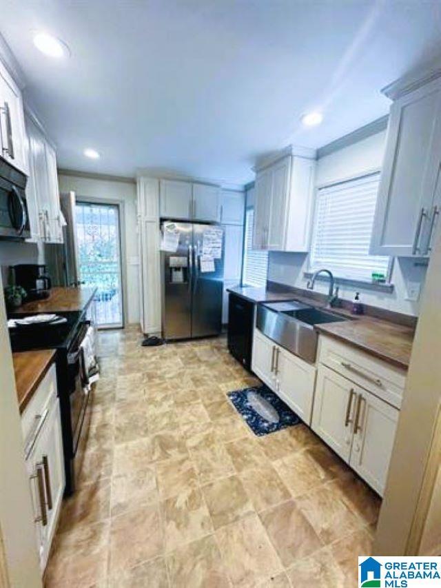 kitchen featuring black appliances, dark countertops, recessed lighting, and a sink