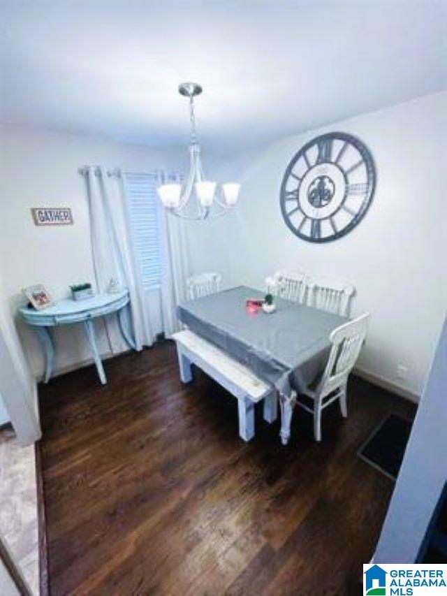dining area featuring wood finished floors and an inviting chandelier