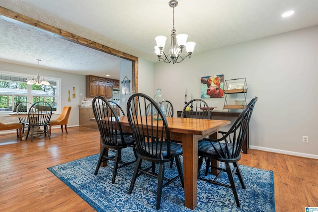 dining room featuring recessed lighting, an inviting chandelier, light wood-type flooring, baseboards, and a textured ceiling