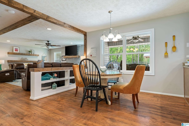 dining space featuring a textured ceiling, wood finished floors, and ceiling fan with notable chandelier