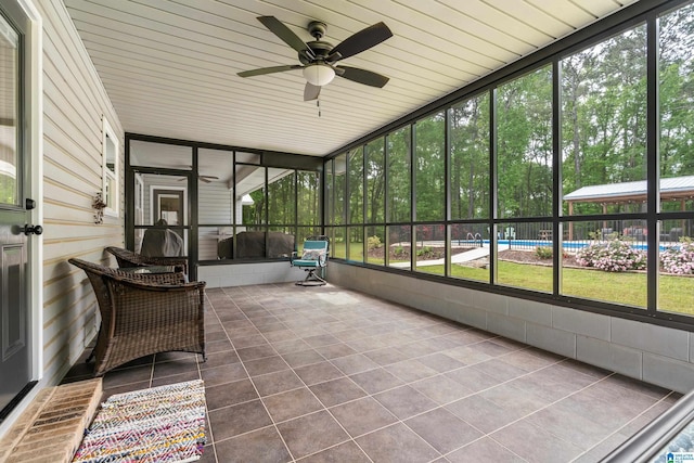 unfurnished sunroom with a ceiling fan