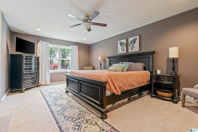 bedroom with a textured ceiling, carpet flooring, ceiling fan, and baseboards