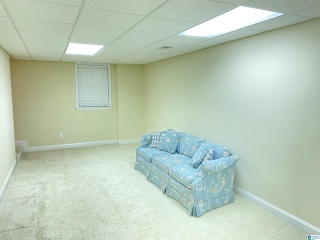 living area with baseboards, carpet, and a paneled ceiling
