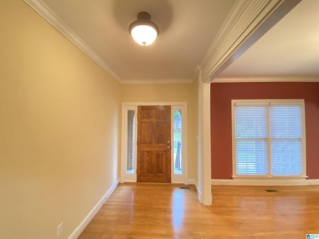 foyer entrance featuring baseboards, visible vents, wood finished floors, and ornamental molding