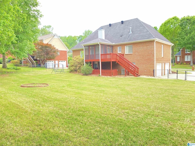 back of property with an attached garage, fence, stairway, brick siding, and a sunroom