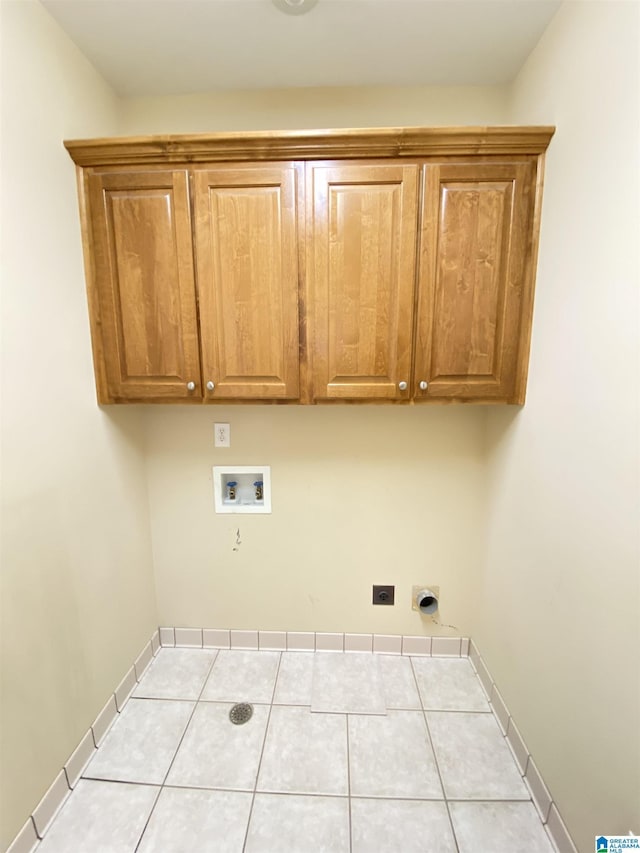 washroom featuring cabinet space, washer hookup, electric dryer hookup, baseboards, and tile patterned flooring