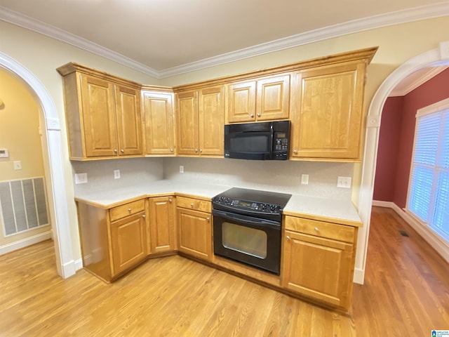 kitchen featuring visible vents, light countertops, arched walkways, black appliances, and light wood-type flooring