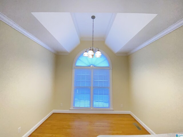 unfurnished room featuring a chandelier, light wood-type flooring, ornamental molding, and baseboards
