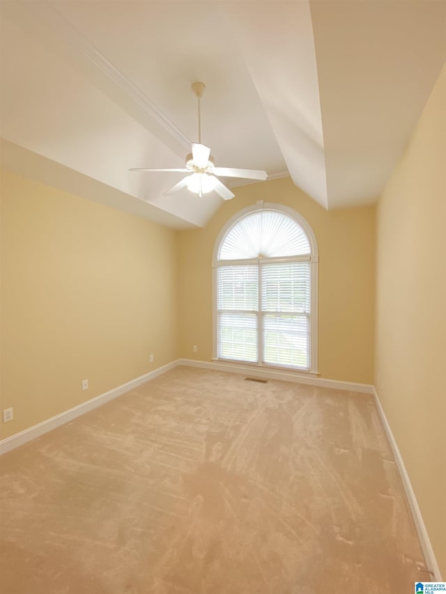 empty room featuring baseboards, light carpet, ceiling fan, and vaulted ceiling