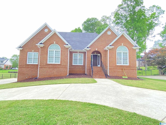 single story home with a front lawn, fence, and brick siding