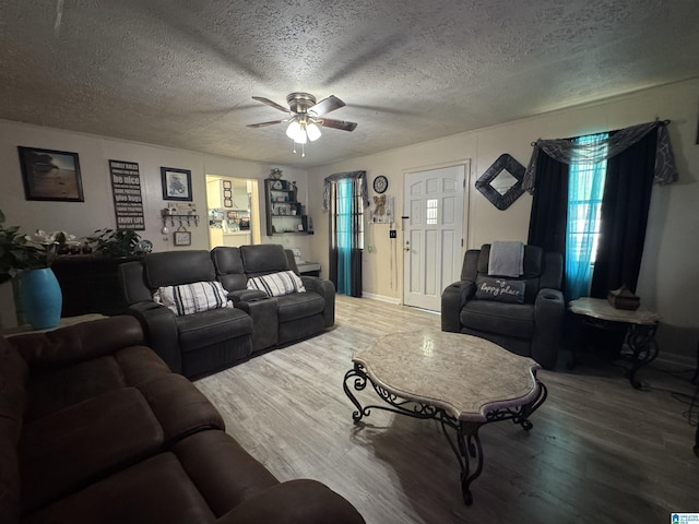 living area featuring wood finished floors, ceiling fan, and a textured ceiling
