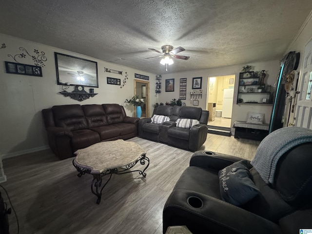 living area with a ceiling fan, baseboards, wood finished floors, and a textured ceiling