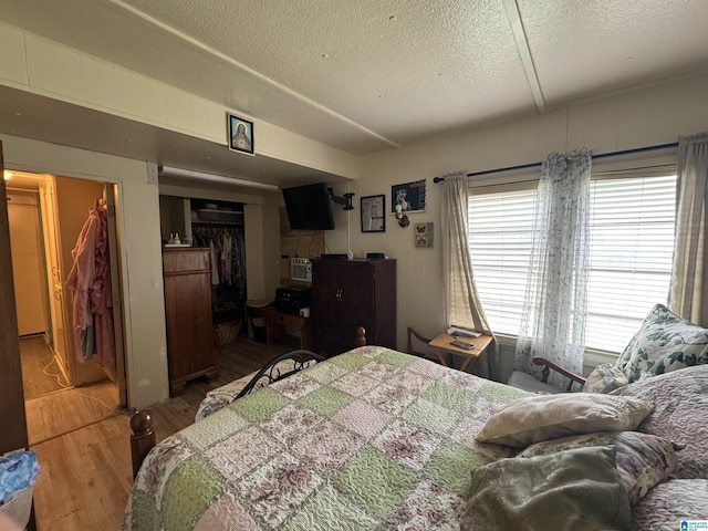 bedroom featuring a textured ceiling, a closet, and wood finished floors
