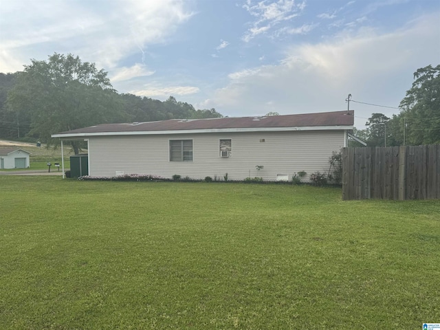 back of house featuring fence and a lawn