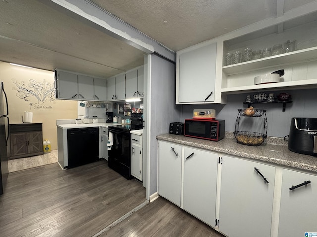 kitchen featuring black appliances, dark wood-style flooring, white cabinets, and light countertops