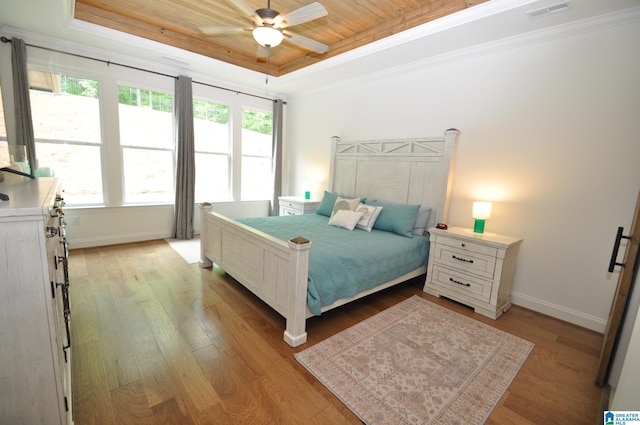 bedroom featuring a raised ceiling, visible vents, wooden ceiling, wood finished floors, and multiple windows