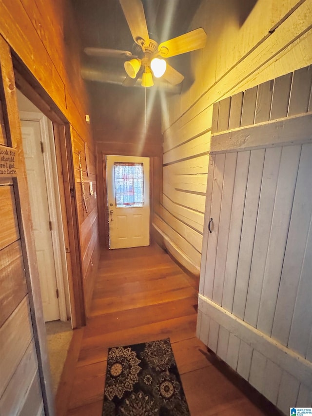 corridor with wooden walls and wood finished floors