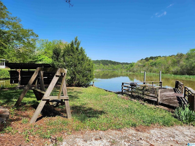 view of dock with a water view and a view of trees