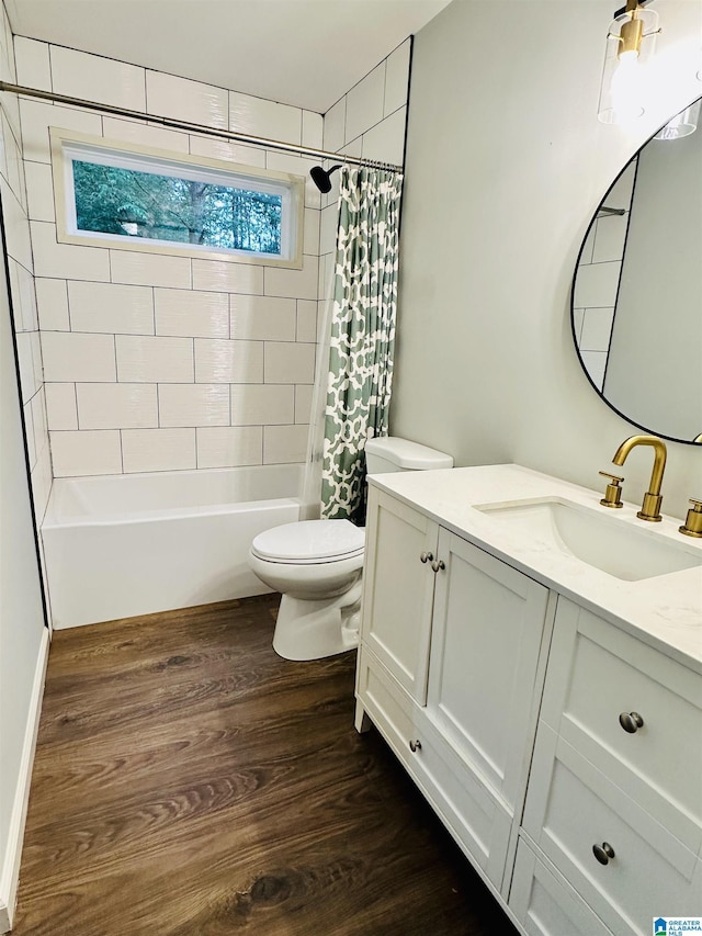 full bath featuring wood finished floors, shower / bath combination with curtain, toilet, and vanity