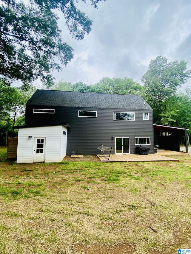 back of property featuring a deck, a yard, and an attached carport