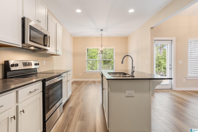 3757 Seaside Sparrow Cir, Bessemer, AL 35022 - kitchen with appliances with stainless steel finishes, dark countertops, light wood-style flooring, and a sink