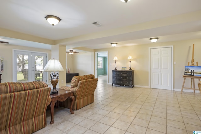living room with visible vents, a ceiling fan, baseboards, and light tile patterned flooring