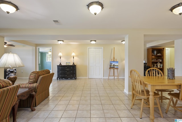 dining area featuring light tile patterned floors, baseboards, ceiling fan, and visible vents