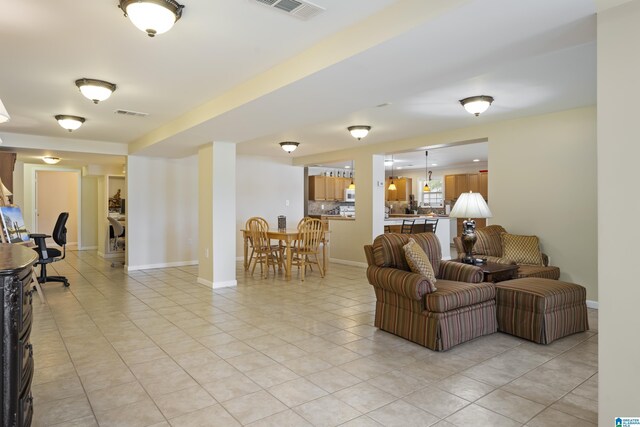 living room with visible vents, baseboards, and light tile patterned floors