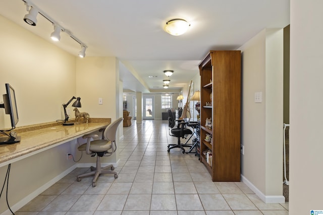 office area with built in study area, rail lighting, baseboards, and light tile patterned floors
